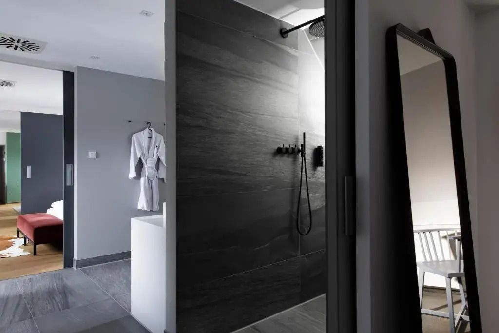 Elegantes Badezimmer der Deluxe Suite mit modernen Armaturen und Regendusche