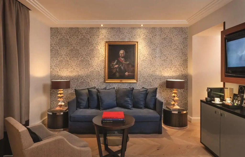 Wohnbereich mit stilvollem Sofa und Porträt an der Wand