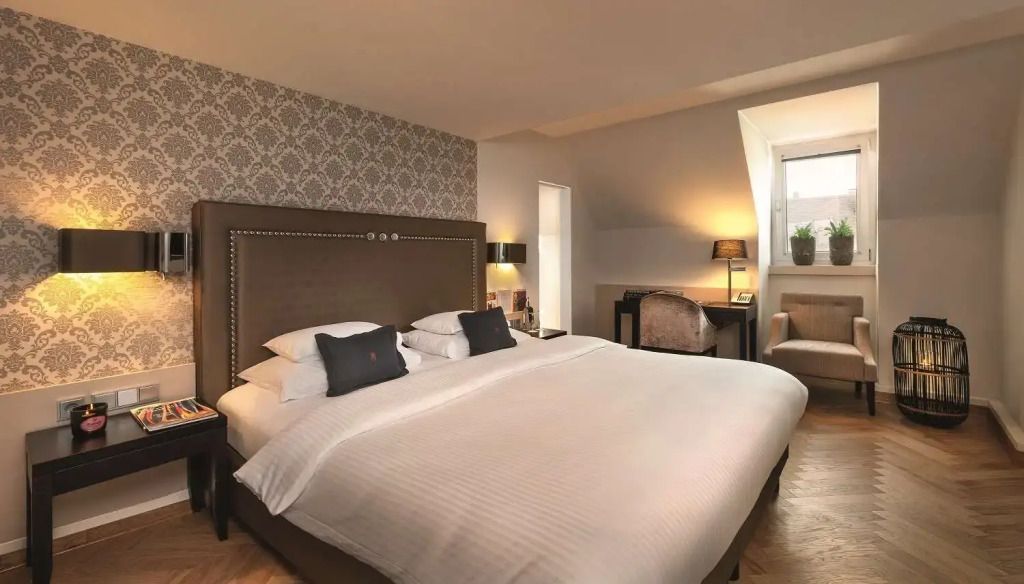 Klassisches Doppelzimmer mit Doppelbett, eleganter Tapete und Schreibtischbereich