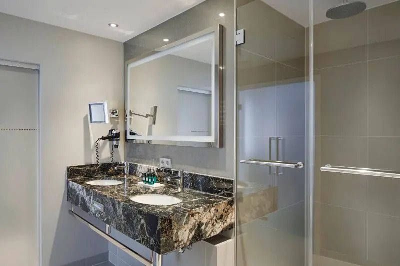 Großes Badezimmer mit Doppelwaschbecken und moderner Dusche