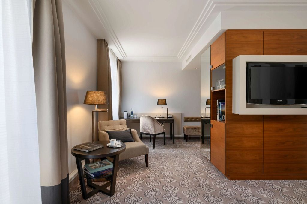 Geräumiges Zimmer mit Schreibtisch, bequemen Sesseln und moderner Einrichtung