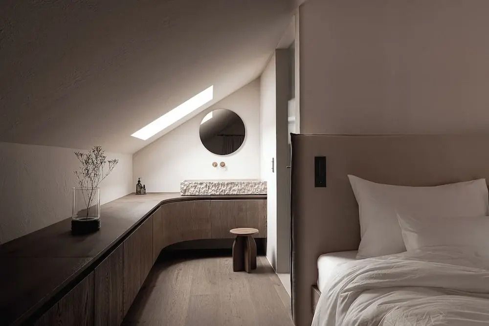Helles Zimmer mit Dachfenster, modernem Design und runden Spiegeln