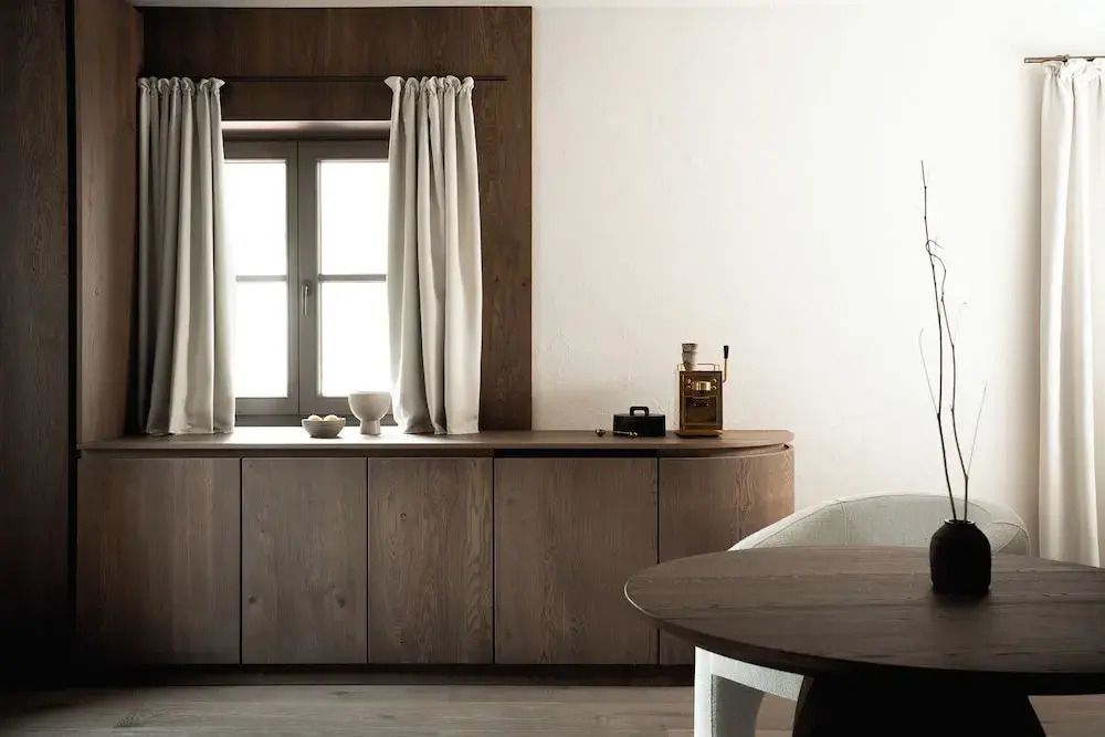 Eleganter Sitzbereich in der Suite mit Holzmöbeln und großen Fenstern.