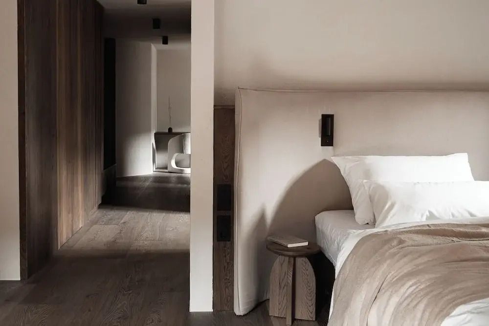 Elegantes Schlafzimmer mit modernem Holzdesign und weichem Licht im Stieg'nhaus Hotel
