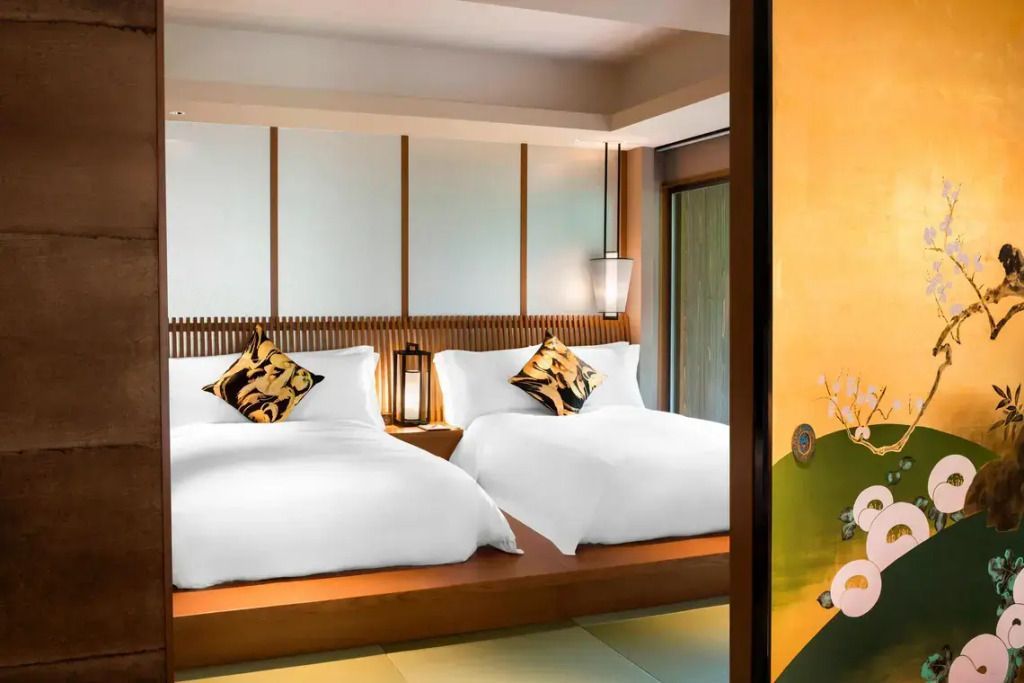 Elegantes Schlafzimmer mit zwei Einzelbetten, kunstvollen Kissen und sanfter Beleuchtung