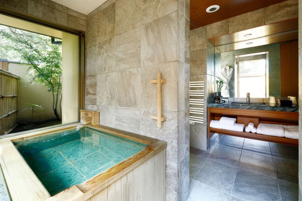 Luxuriöses Badezimmer mit Onsen-Bad aus Holz und stilvoller Einrichtung