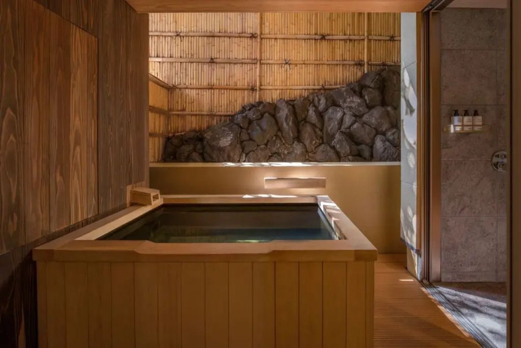 Privates Onsen mit Holzwänden umgeben von Felsen für ein authentisches Erlebnis