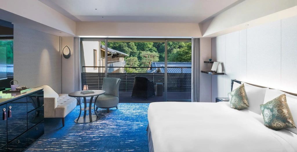 Geräumiges Schlafzimmer mit Blick auf einen Balkon und grüne Landschaft.