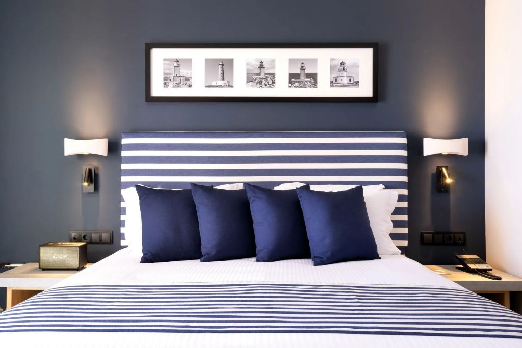 Honeymoon Suite mit gestreiftem Kopfteil und blauen Kissen auf dem Bett