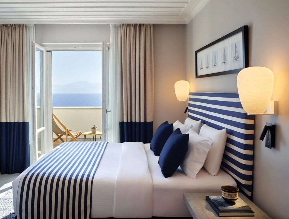 Luxuriöses Doppelbett mit Blick auf den blauen Ozean im Hintergrund