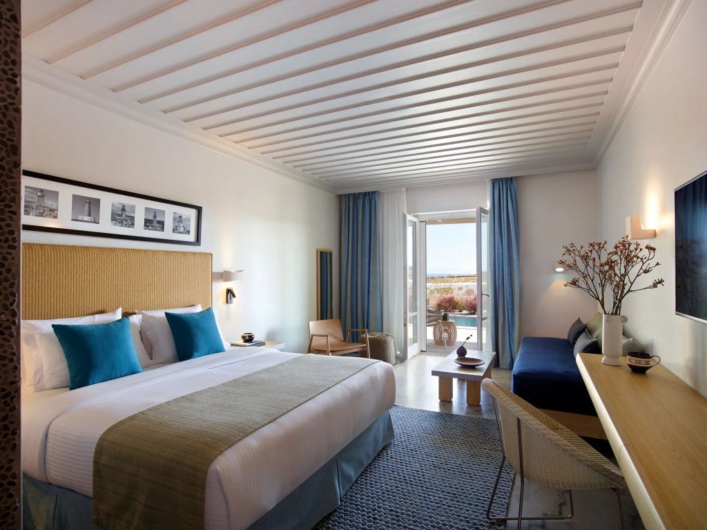 Helles Zimmer mit Doppelbett und Meerblickbalkon in luxuriösem Resort