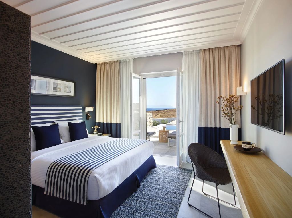 Elegantes Zimmer mit Doppelbett, Blick auf den Balkon und Meer in einer luxuriösen Suite