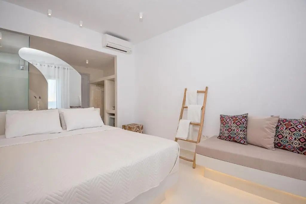 Helles Schlafzimmer mit Doppelbett, minimalistisch dekoriert mit Kissen und Handtüchern