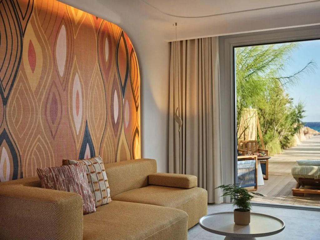 Elegantes Hotelzimmer mit gemütlicher Sitzecke und Wandkunst in warmen Farbtönen