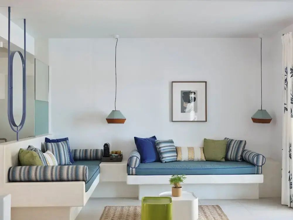 Stylisher Wohnbereich in der Suite mit gemütlichen Sofas und farbigen Kissen.