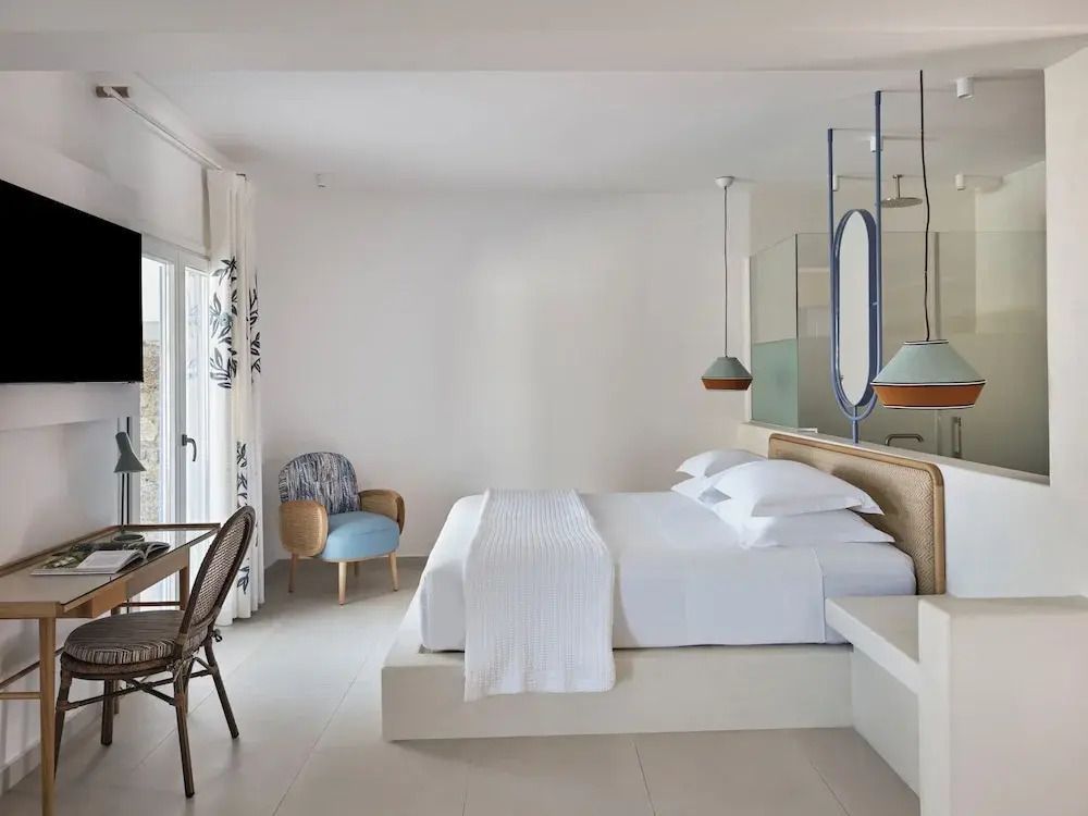 Schlafzimmer mit großem Bett und elegantem, minimalistischem Dekor.