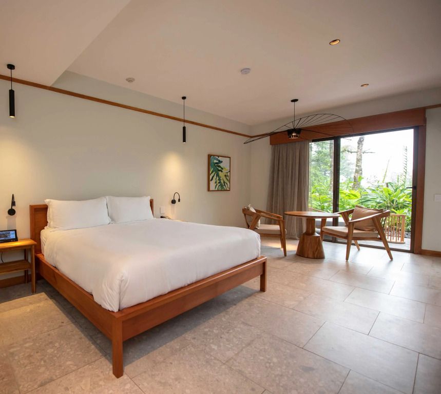 Helles Doppelzimmer mit modernen Möbeln und Glasschiebetür zur Terrasse.