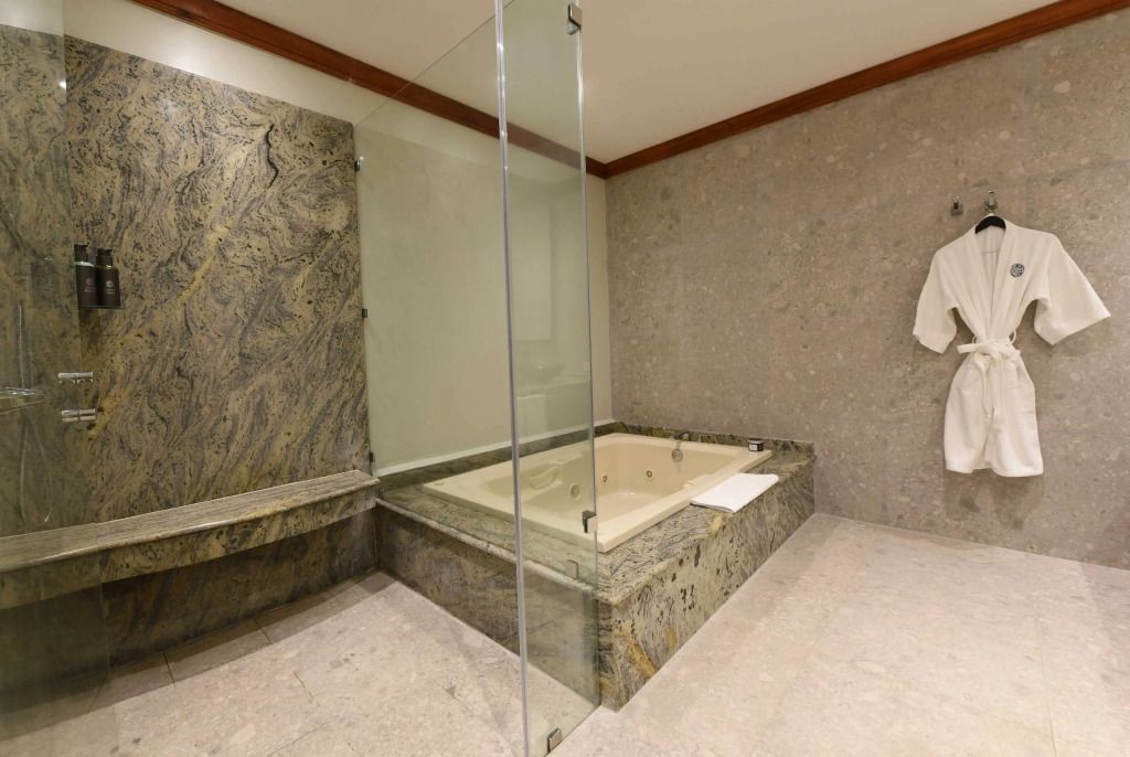 Luxuriöses Badezimmer mit Whirlpool und gläserner Duschabtrennung.