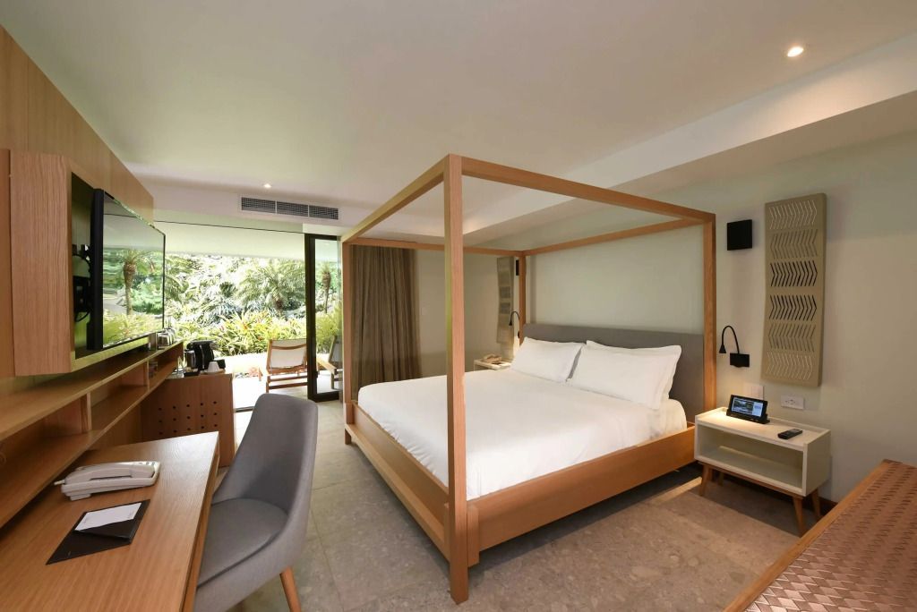Suite mit großem Himmelbett und Blick auf die grüne Umgebung.