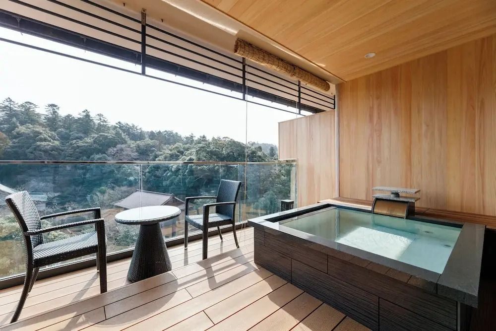 Balkon mit privatem Onsen und Sitzbereich aus Holz mit Blick auf die Natur