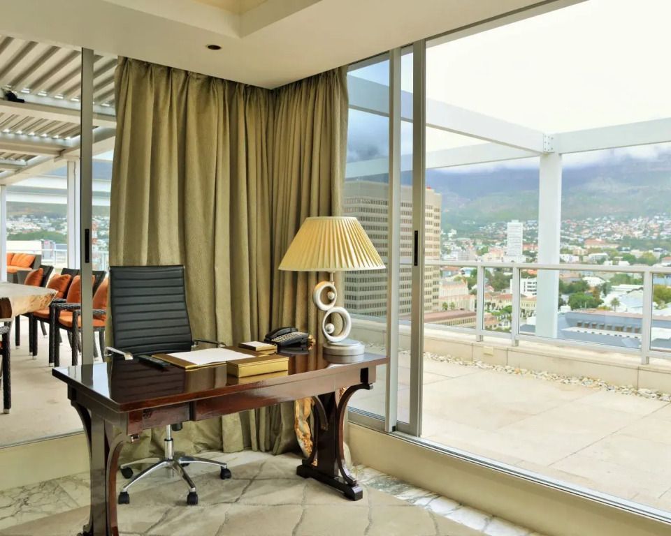 Arbeitsbereich mit Schreibtisch in der Präsidenten Vierer Suite mit Blick auf Stadt
