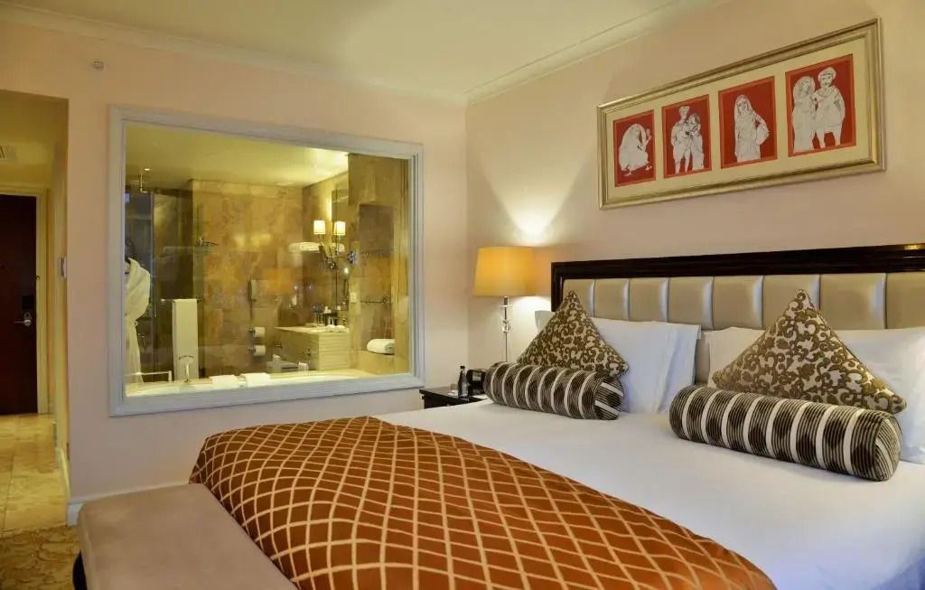 Gemütliches Doppelzimmer mit großen Kissen und Blick ins Badezimmer.