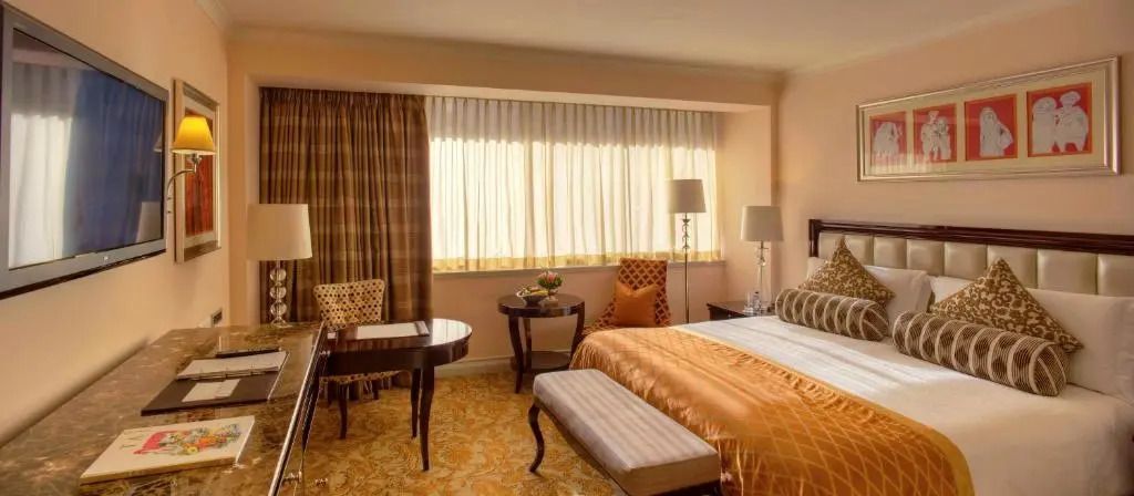 Hotelzimmer mit breitem Fenster und elegantem, warmem Interieur.