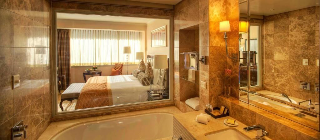 Luxuriöses Badezimmer mit Wanne und Durchblick ins Schlafzimmer.