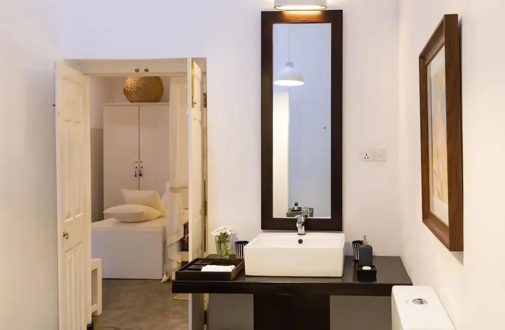 Modernes Badezimmer mit stilvollem Waschbecken und Spiegel, Aussicht auf Schlafzimmer
