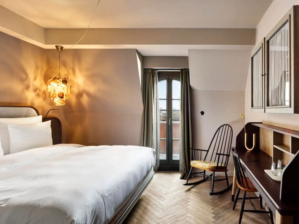 Doppelzimmer mit modernem Design und Balkonblick über die Stadt