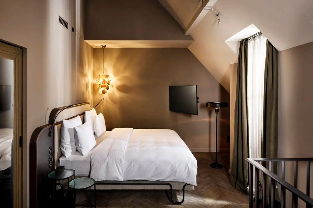 Modern eingerichtetes Hotelzimmer mit gemütlichem Bett und stilvoller Beleuchtung