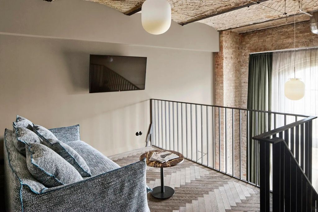 Obere Ebene eines Maisonette-Zimmers mit Fernseher und dekorativem Tisch