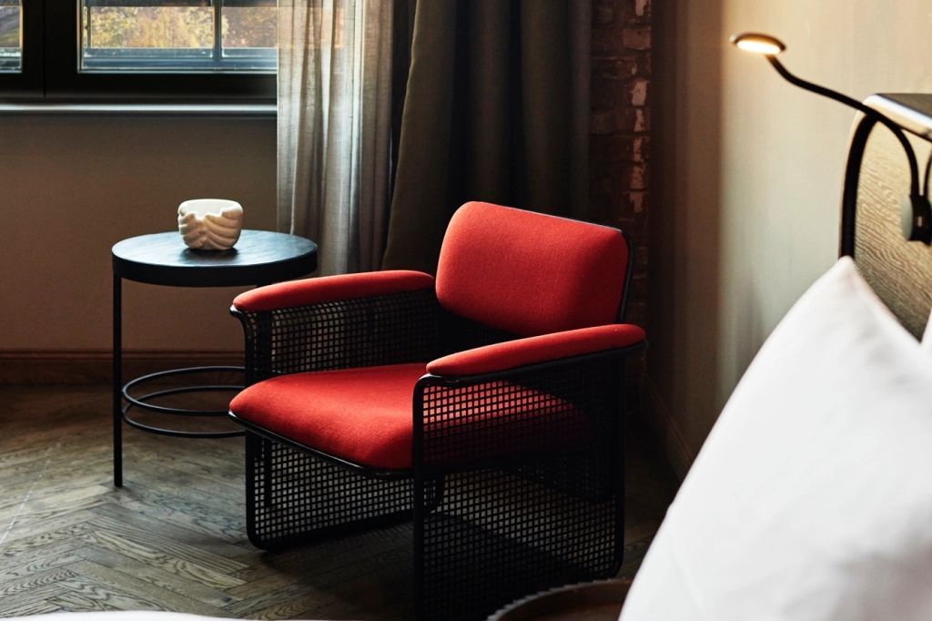 Roter Sessel in einem stilvollen Zimmer mit Holzboden und Fenstern