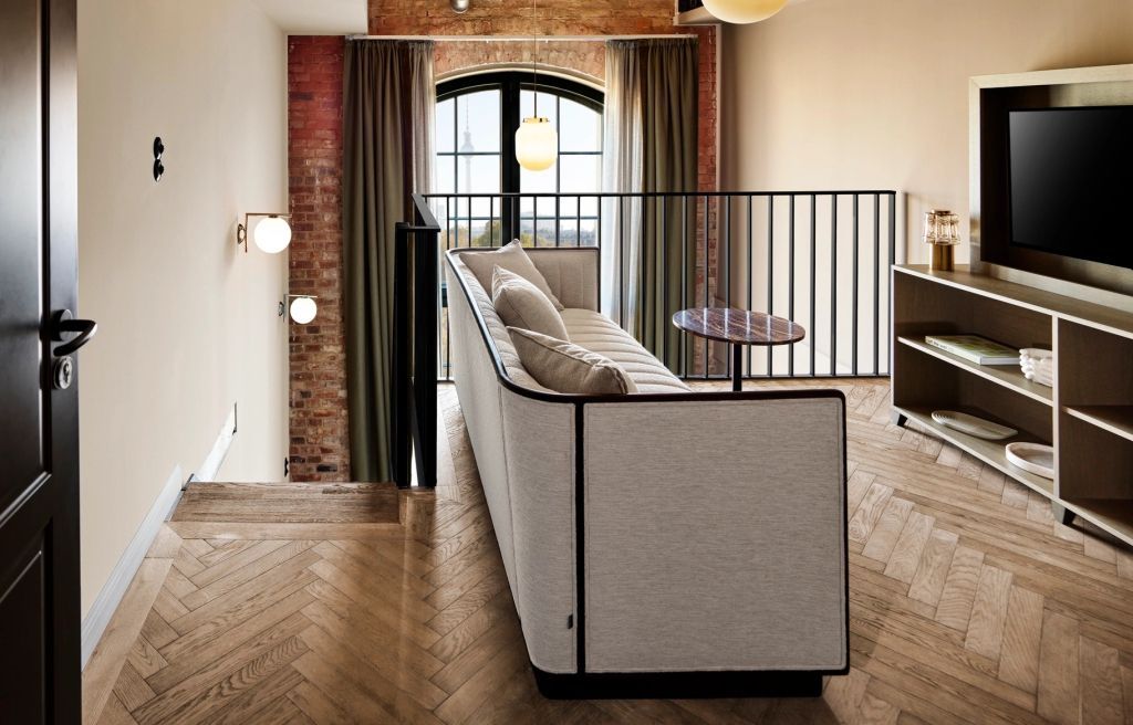 Maisonette-Lounge mit modernem Sofa und großen bodennahen Fenstern