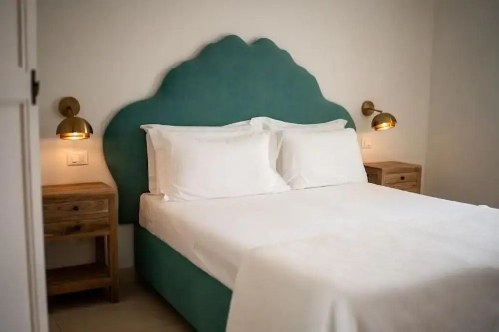 Helles Schlafzimmer mit Doppelbett und türkisfarbenem Kopfteil
