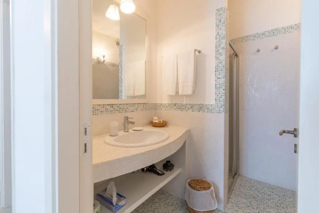 Modernes Badezimmer mit Waschbecken, Spiegel und Dusche.