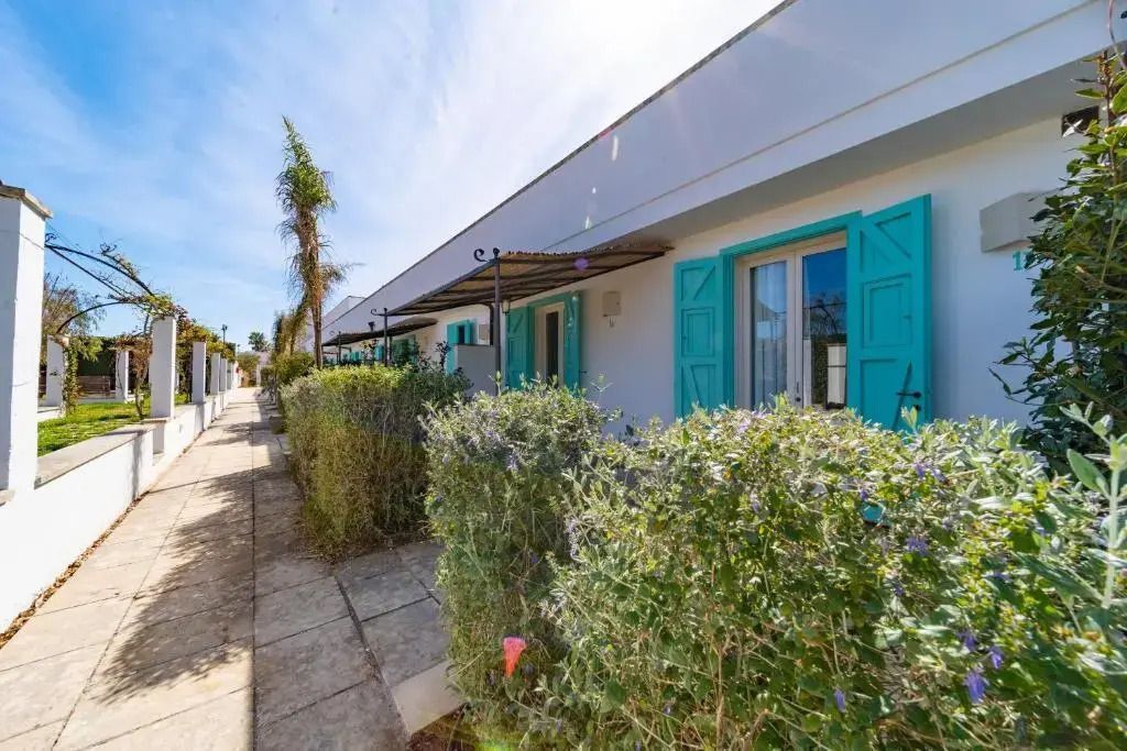 Außenansicht der Suite mit blauen Fensterläden und üppigem Garten