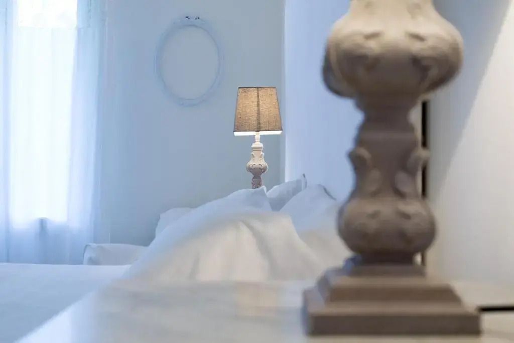 Detailansicht einer stilvollen Lampe neben einer eleganten Bettstruktur.