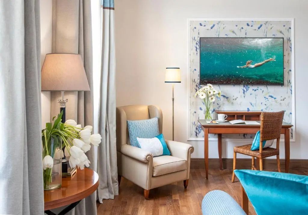 Stilvolle Sitzecke mit Sessel und blauen Details im Deluxe Zimmer