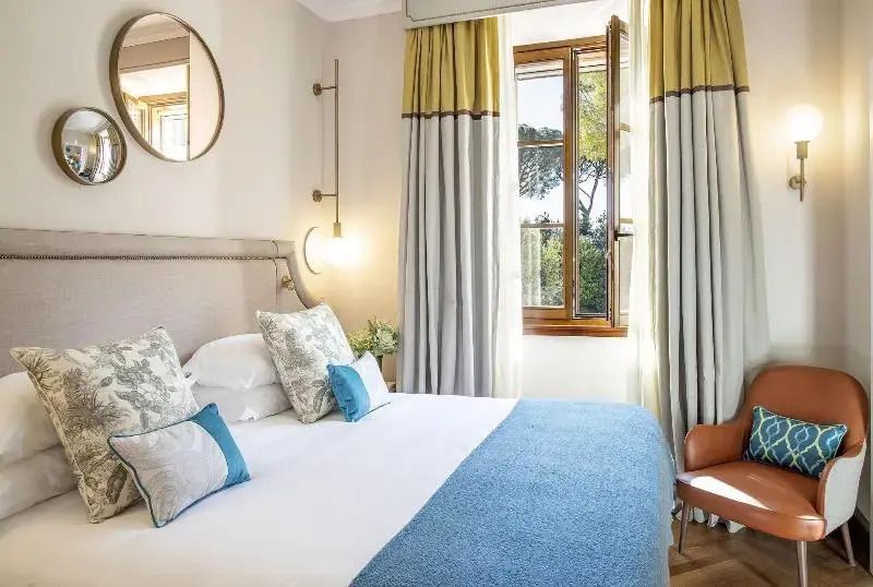 Elegantes Schlafzimmer mit Doppelbett in sanften Farben und großen Fenstern