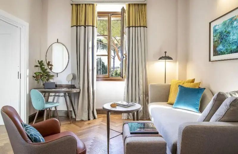 Wohnbereich mit Schreibtisch und Sofa in warmen Tönen und großzügigem Tageslicht