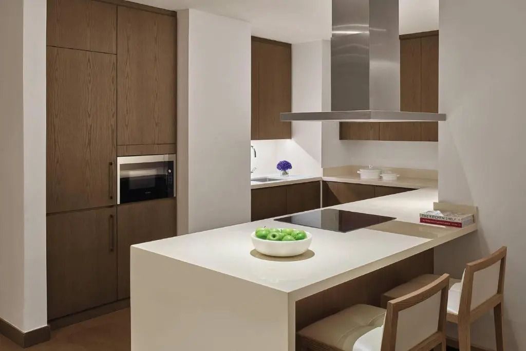 Moderne Küche mit Holzschränken und Kochinsel mit Barhockern.