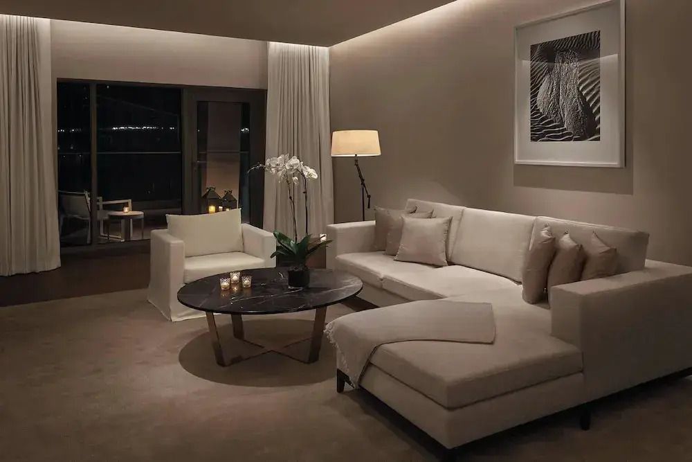 Luxe Wohnzimmer mit bequemer Couch, stilvollem Sessel und dezenter Beleuchtung