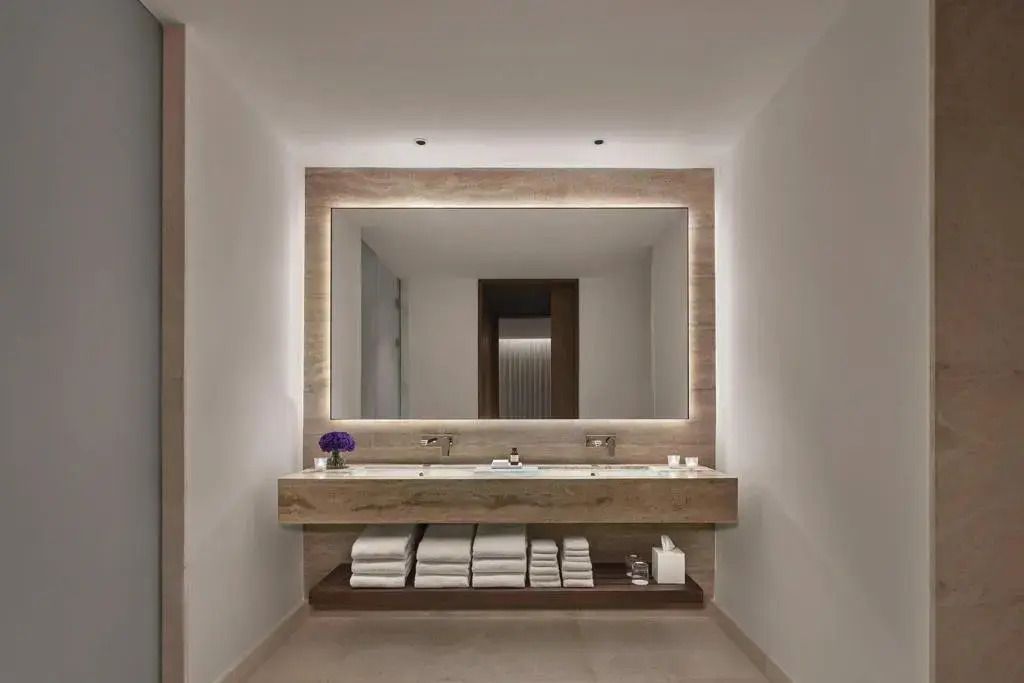 Modernes Badezimmer mit großem Spiegel und eleganter Beleuchtung