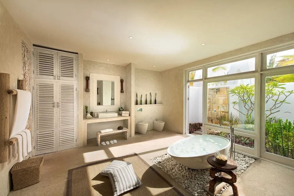 Großes Badezimmer mit freistehender Badewanne und Gartenzugang