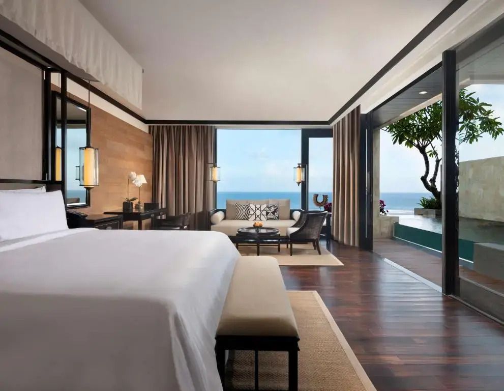 Großes Schlafzimmer mit Blick auf den Ozean und Zugang zum privaten Pool.