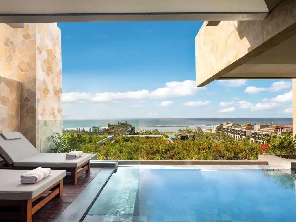 Infinity-Pool auf Terrasse mit Blick auf den tropischen Garten und das Meer.