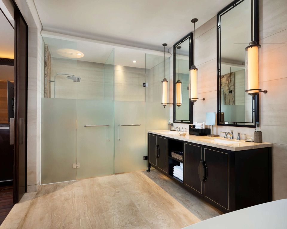 Modernes Badezimmer mit zwei Waschbecken und großer Dusche.