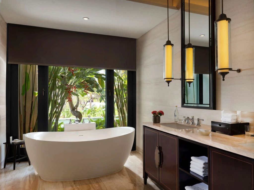 Luxuriöses Badezimmer mit freistehender Badewanne und Gartenblick.