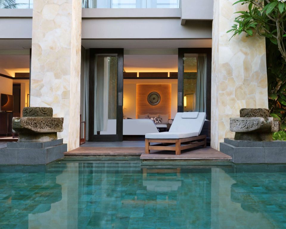 Luxuriöses Zimmer mit direktem Zugang zu einem Lagunenpool und eleganter Liegefläche.